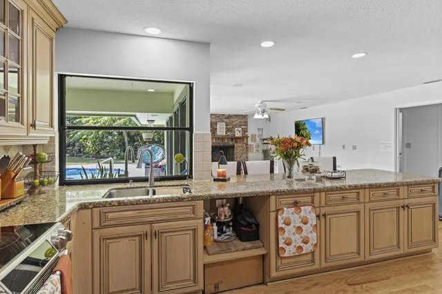 a view of a swimming pool with lawn chairs under an umbrella