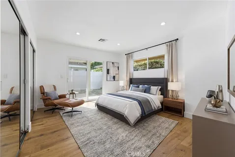 a spacious bedroom with a bed and wooden floor