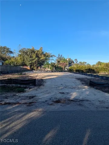 a view of dirt road with a building in the background