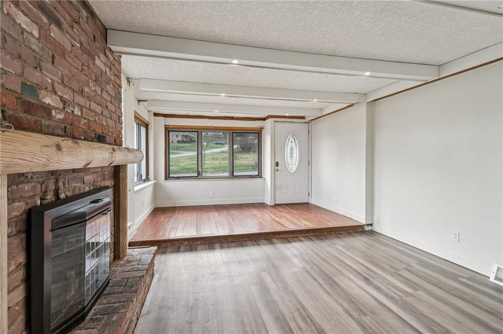32 Stadium Road Millsboro, PA 15348 - Photo 12 of 47 a view of an empty room with wooden floor fireplace and a window