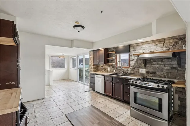 a kitchen with stainless steel appliances granite countertop a stove top oven and sink