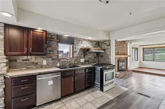 a kitchen with stainless steel appliances granite countertop a stove and a sink