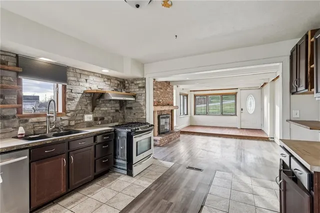 a large kitchen with stainless steel appliances granite countertop a stove and a sink