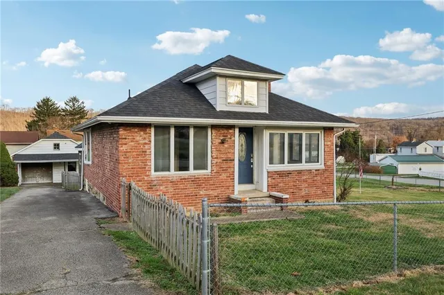 a front view of a house with a yard table and chairs