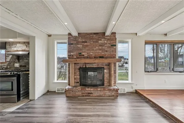 an empty room with fireplace and wooden floor