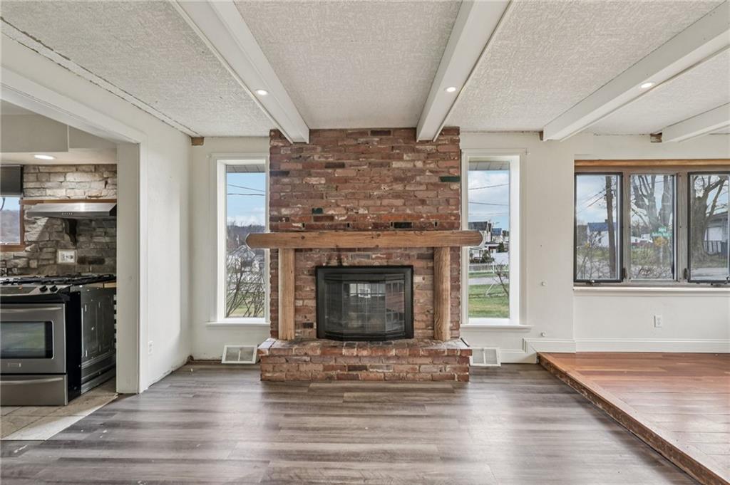 32 Stadium Road Millsboro, PA 15348 - Photo 8 of 47 an empty room with fireplace and wooden floor