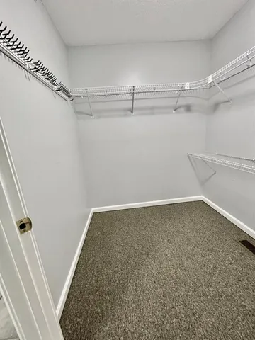 an empty room with closet and a ceiling fan