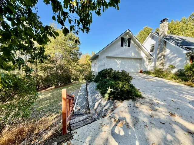 a view of a garden with a bench and trees around
