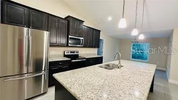 a kitchen with kitchen island a counter top space cabinets and stainless steel appliances