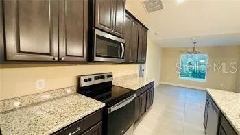 a kitchen with granite countertop cabinets stainless steel appliances and a counter top