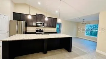 a kitchen with kitchen island a sink stainless steel appliances and cabinets