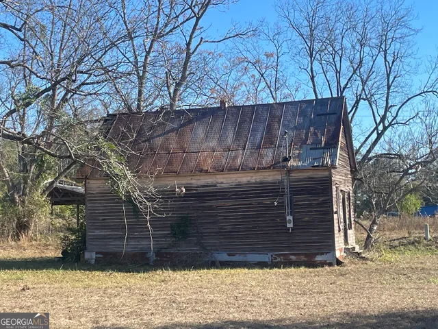 a view of a house with a tree and wooden fence