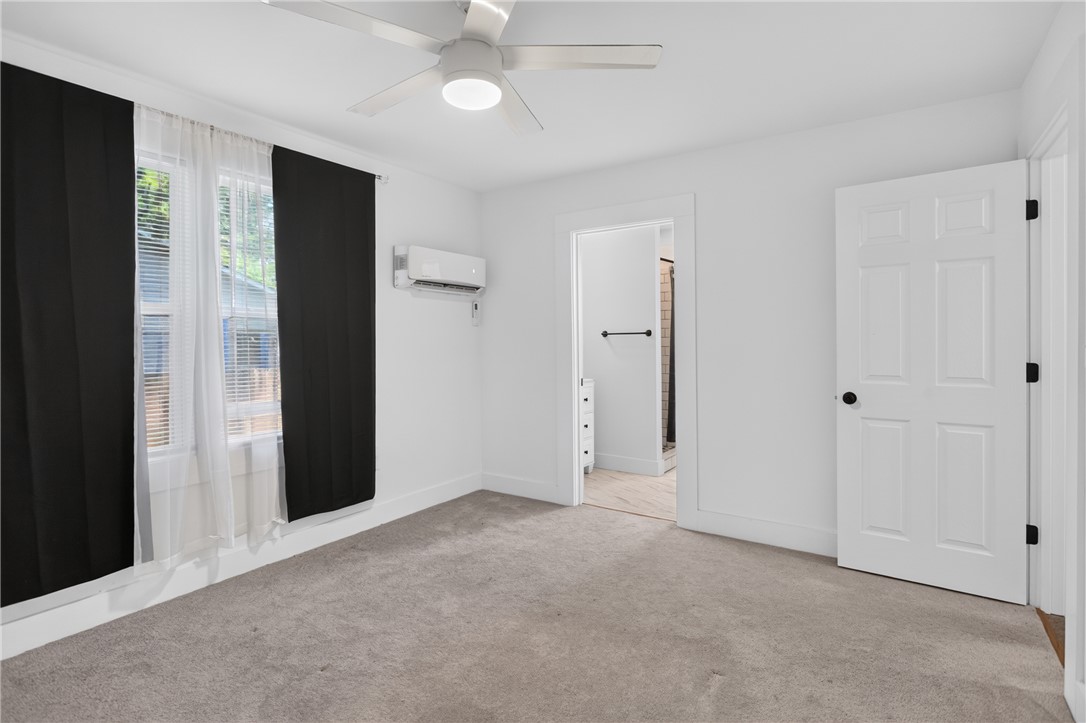 115 Pelfrey Street Seneca, SC 29672 - Photo 26 of 46 A well-lit bedroom with fresh carpet, ceiling fan, and private bath access awaits.