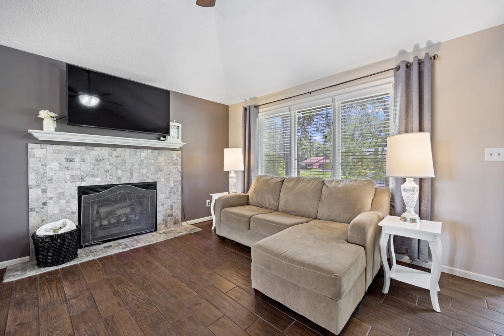 5568 Gray Eagle Road Roscoe, IL 61073 - Photo 11 of 45 a living room with furniture a flat screen tv and a fireplace
