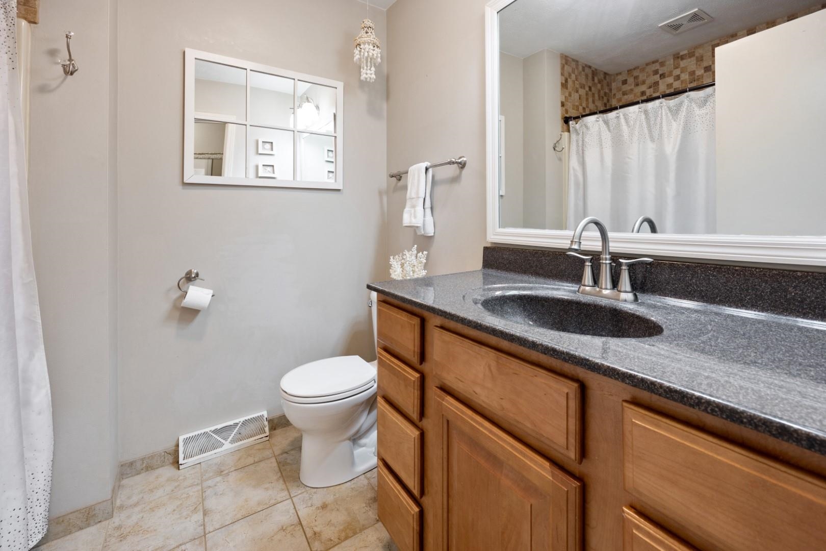 5568 Gray Eagle Road Roscoe, IL 61073 - Photo 21 of 45 a bathroom with a granite countertop toilet sink and mirror