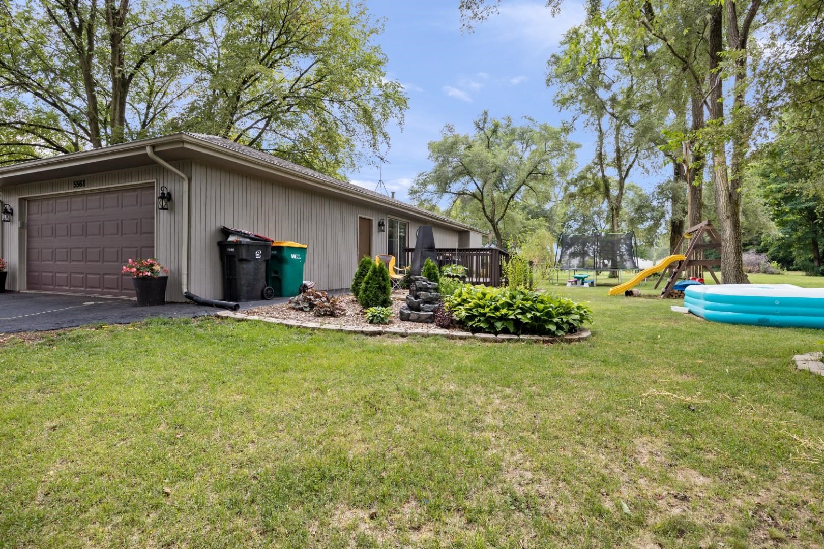 5568 Gray Eagle Road Roscoe, IL 61073 - Photo 41 of 45 a backyard of a house with table and chairs