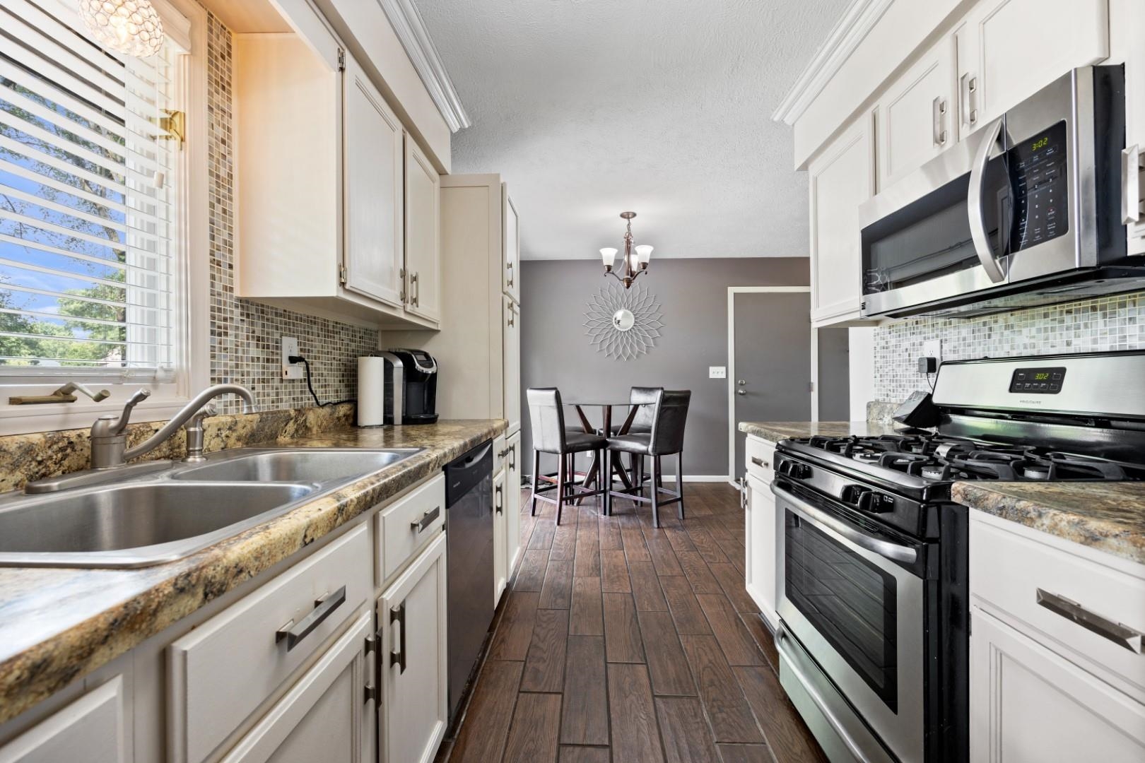 5568 Gray Eagle Road Roscoe, IL 61073 - Photo 5 of 45 a kitchen with stainless steel appliances a stove a sink and a microwave