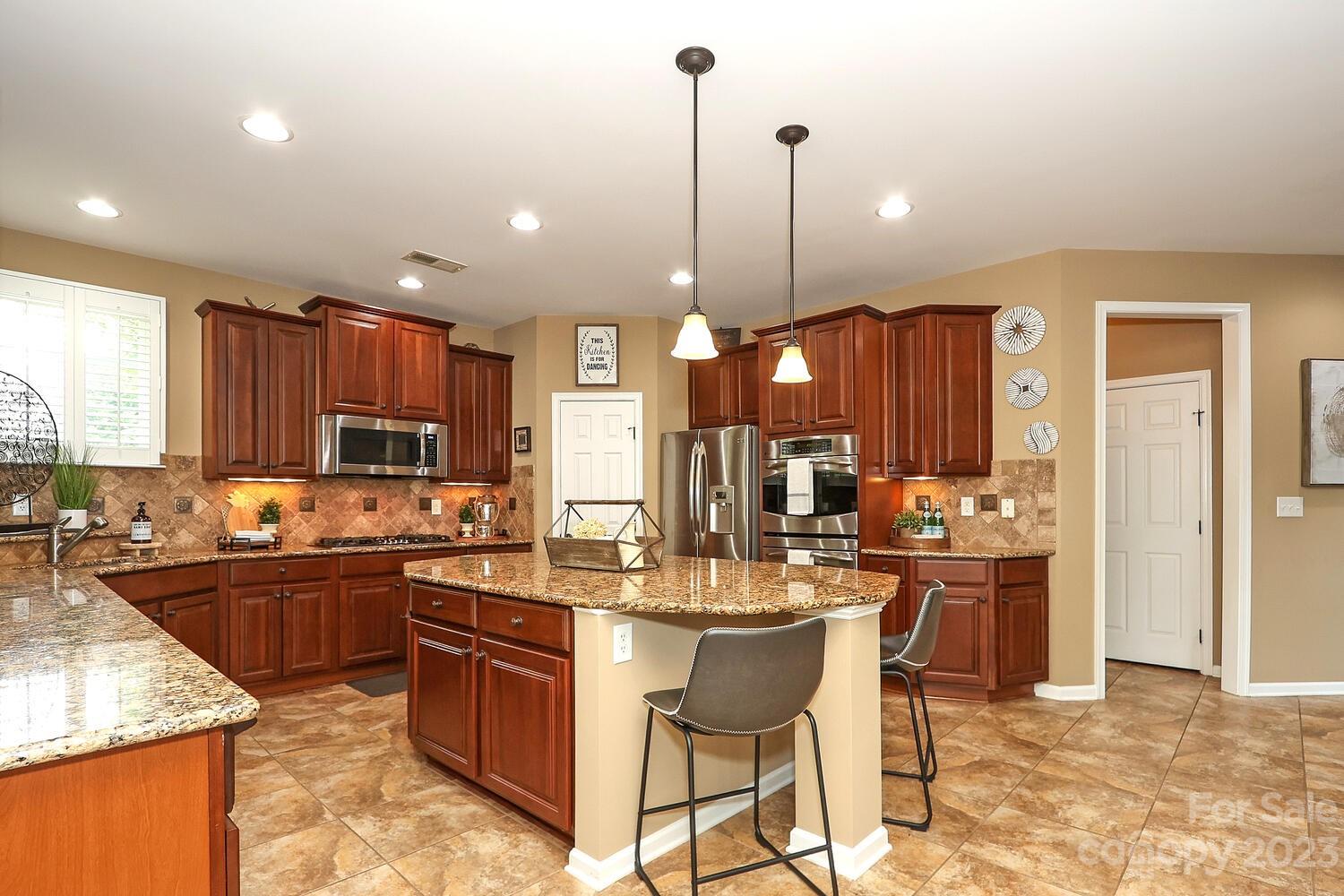 209 Fischer Road Fort Mill, SC 29715 - Photo 12 of 36 a kitchen with stainless steel appliances kitchen island granite countertop a sink stove and refrigerator