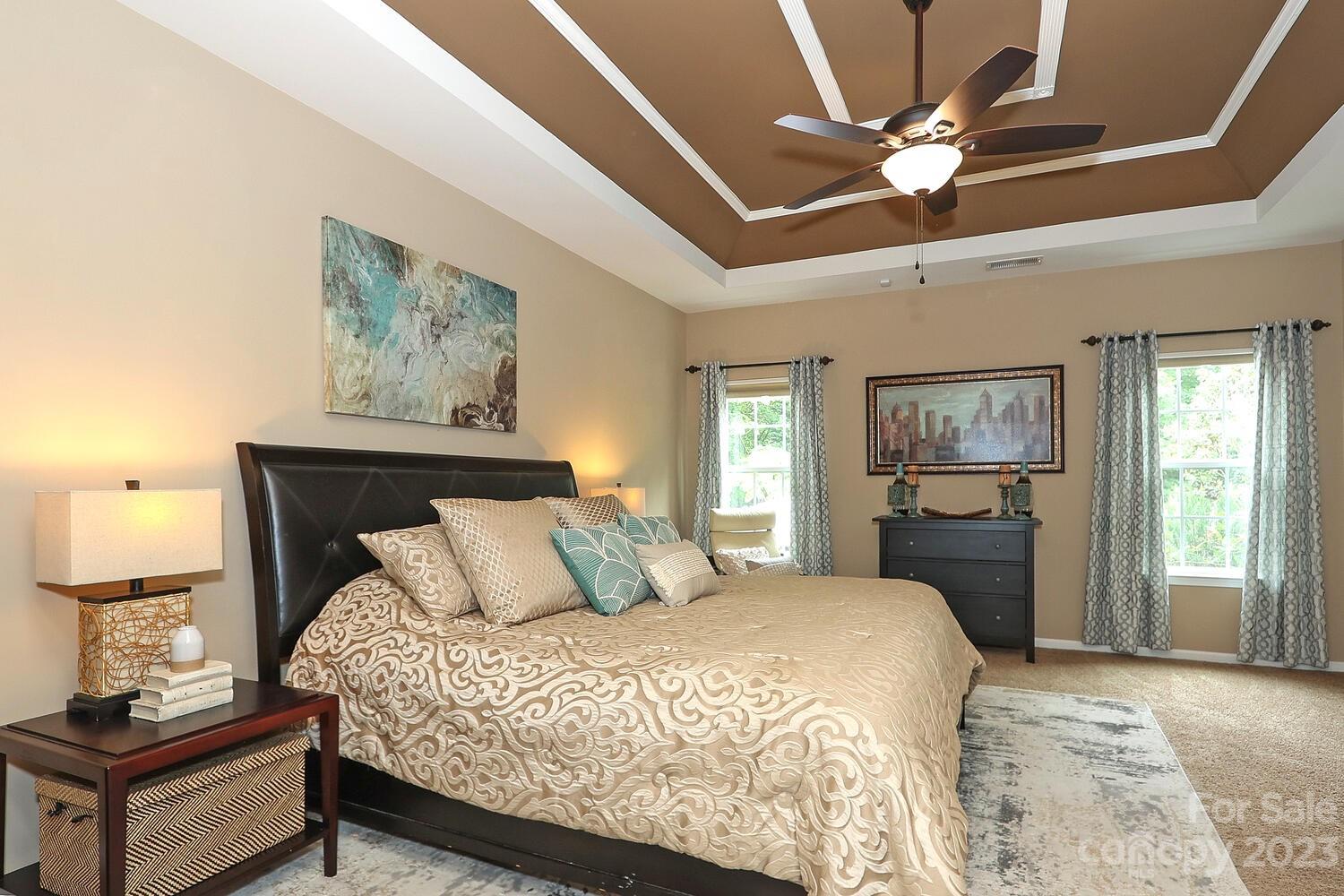 209 Fischer Road Fort Mill, SC 29715 - Photo 20 of 36 a bedroom with a large bed and a chandelier