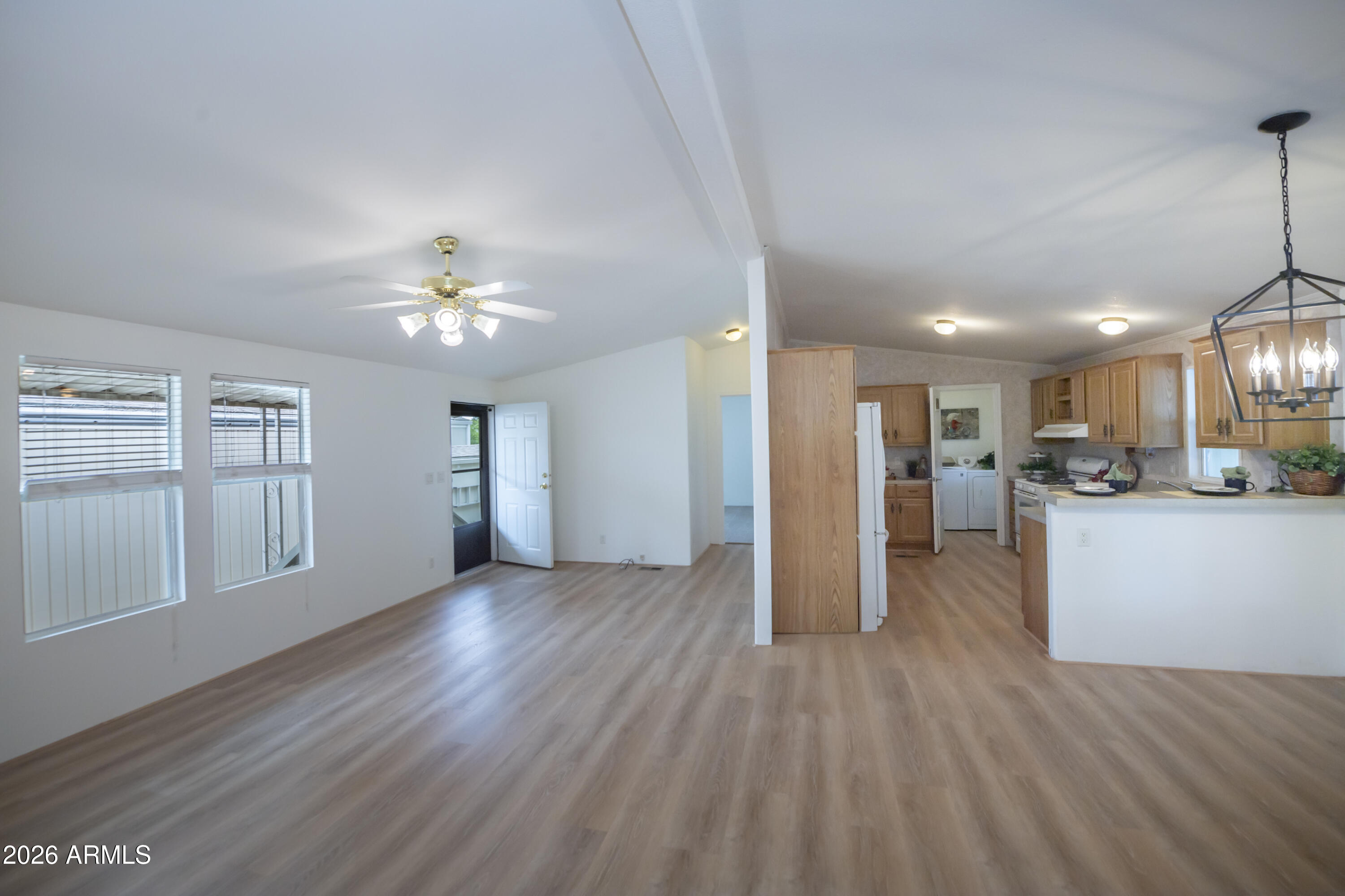 11250 East State Rte 69, Unit 1125 Dewey, AZ 86327 - Photo 33 of 45 a view of an empty room and kitchen with wooden floor