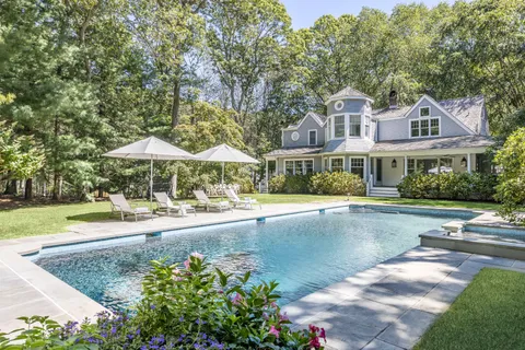 a front view of a house with swimming pool and porch