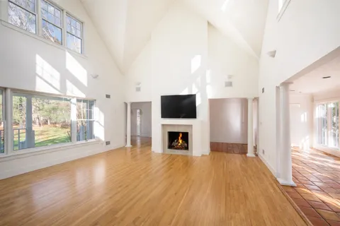 a view of a livingroom with a fireplace wooden floor and window