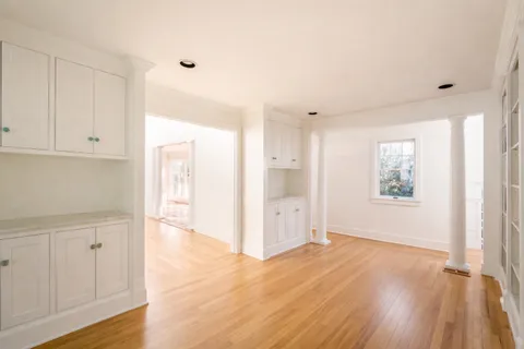 a view of an empty room with closet and a window