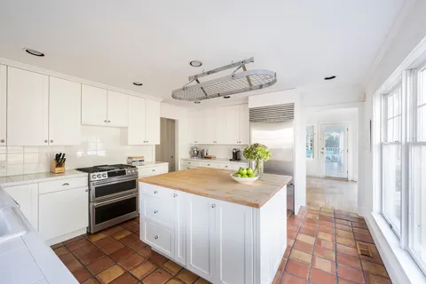 a kitchen with granite countertop a sink stove and cabinets