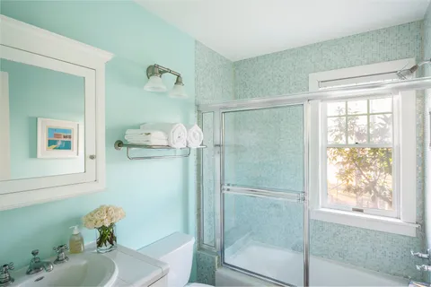 a bathroom with a shower sink and mirror