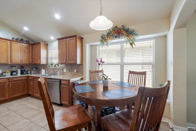 a kitchen with a table chairs sink and cabinets