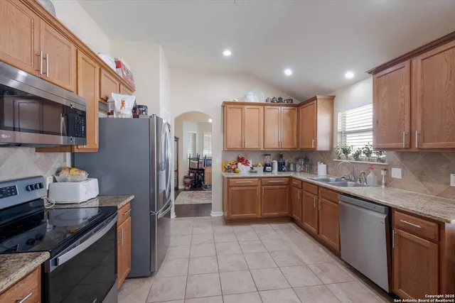 a kitchen with stainless steel appliances granite countertop a sink stove and refrigerator