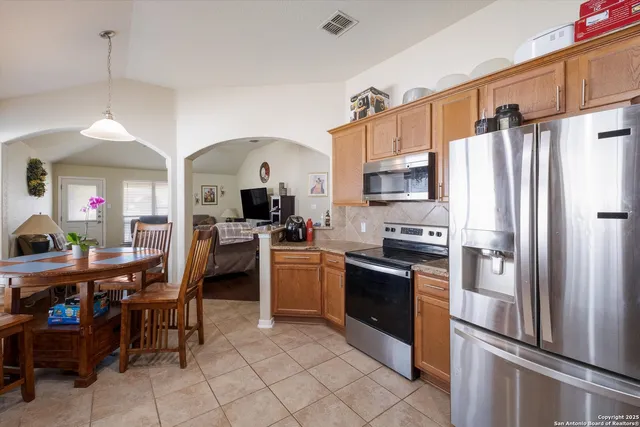 a kitchen with stainless steel appliances granite countertop a refrigerator and a stove top oven