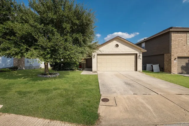 a front view of a house with a yard and trees