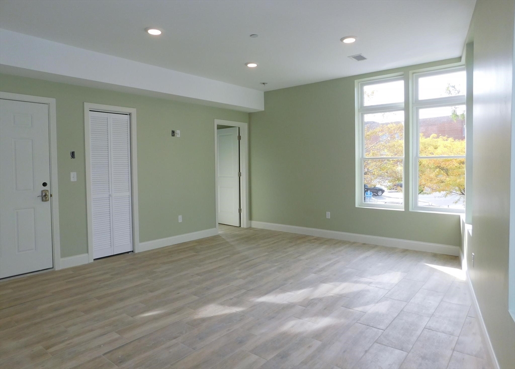 10 Roxbury Street, Unit 8 Boston, MA 02119 - Photo 10 of 10 a view of an empty room with wooden floor and a window