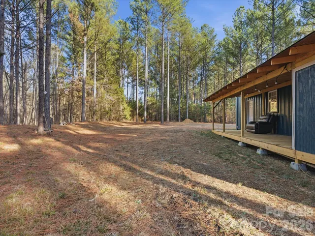 a view of a house with backyard and trees
