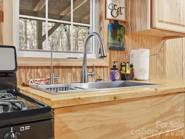 a kitchen with stainless steel appliances granite countertop a refrigerator a stove and a sink