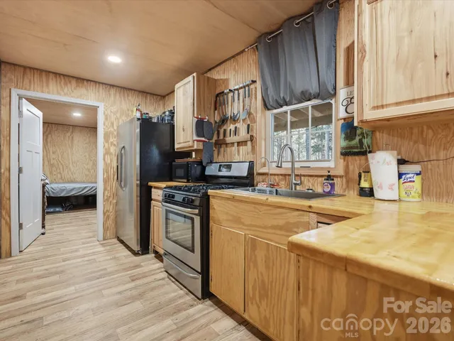a view of a kitchen with kitchen island wooden floor entryway