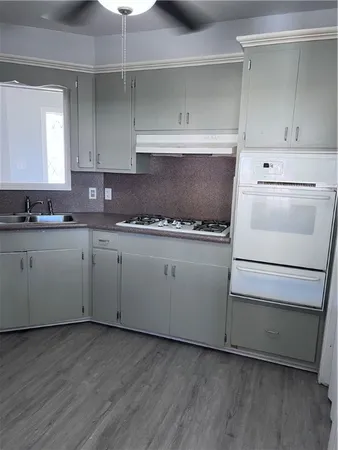 a kitchen with cabinets appliances and wooden floor
