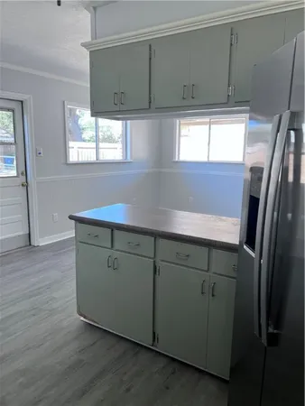 a kitchen with cabinets and wooden floors