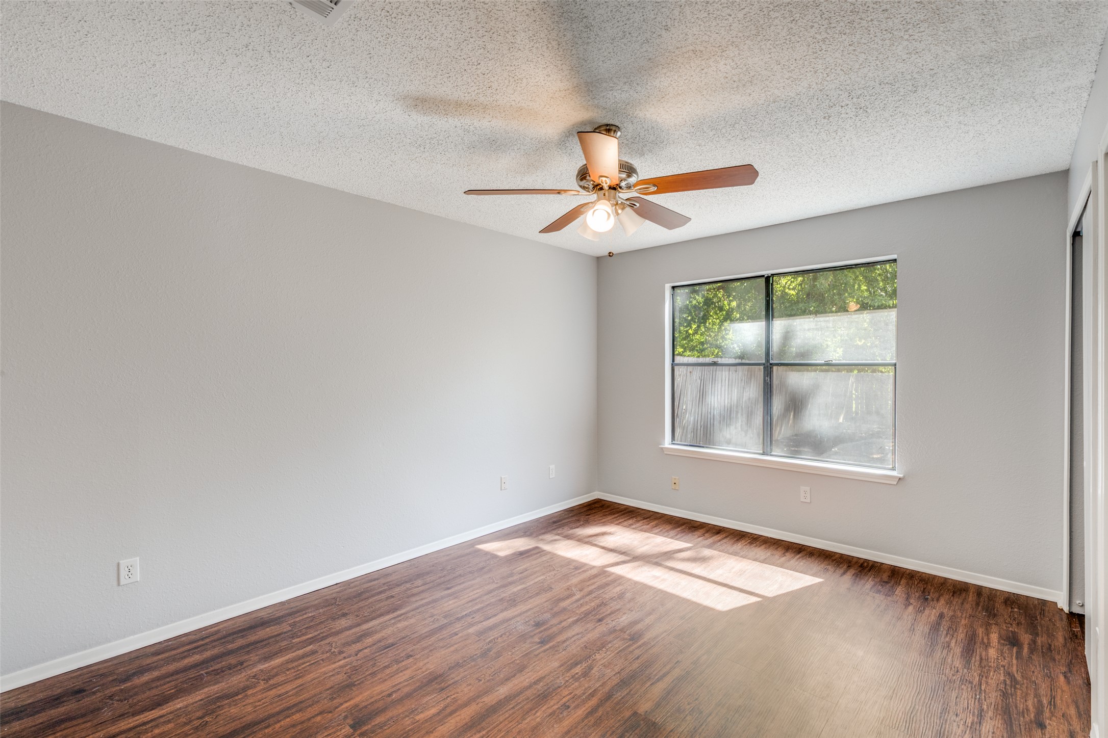 12323 Little Emily Way Austin, TX 78753 - Photo 13 of 24 an empty room with wooden floor fan and windows