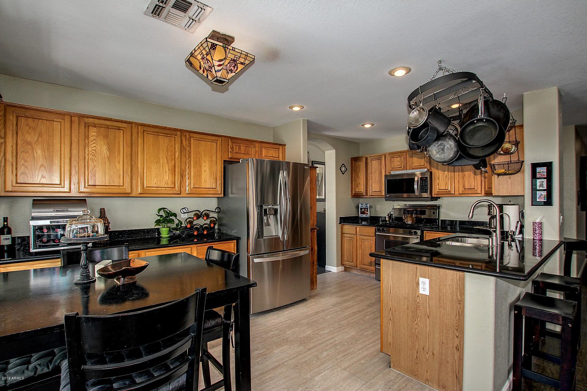 462 West Colt Road Tempe, AZ 85284 - Photo 7 of 29 a kitchen with stainless steel appliances a dining table chairs stove and refrigerator