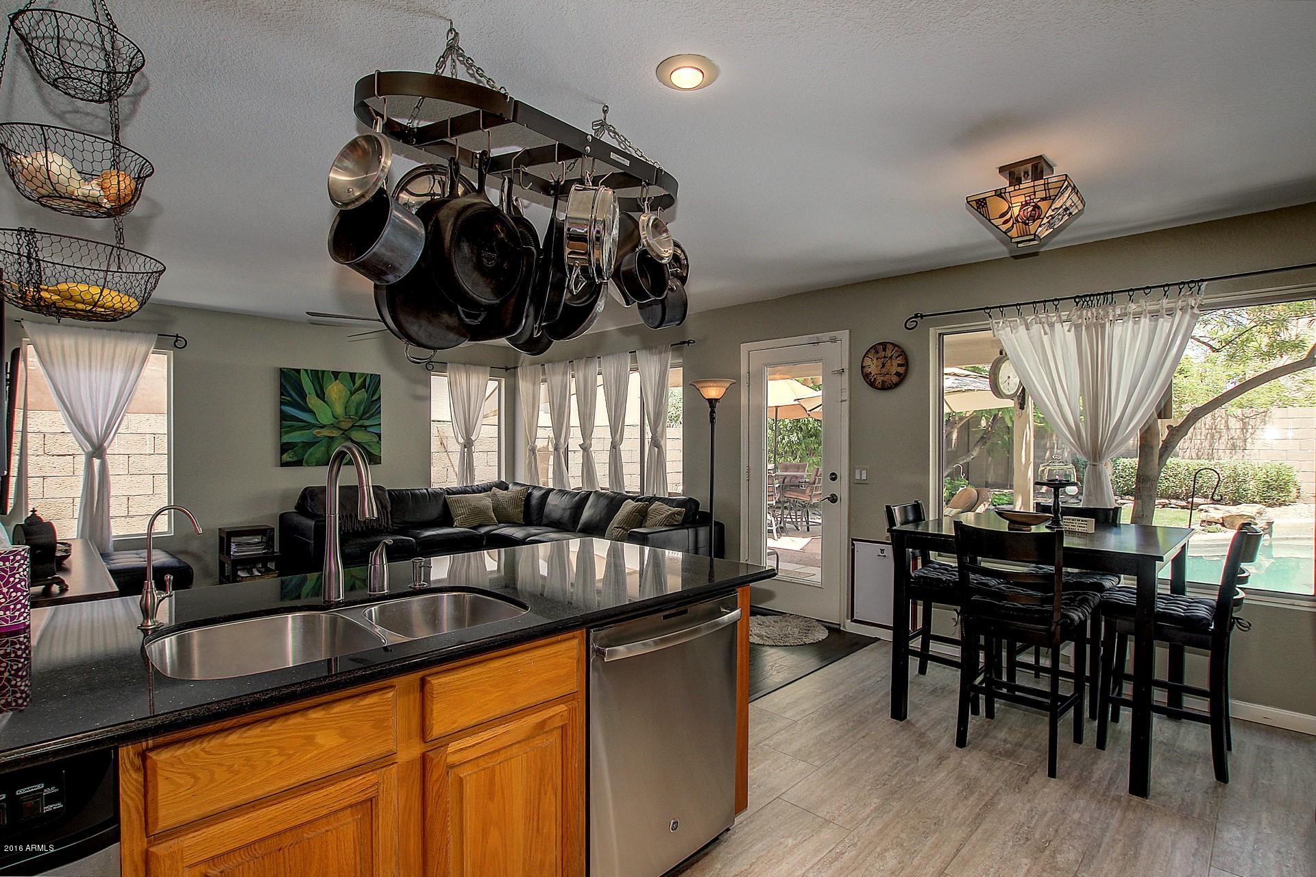 462 West Colt Road Tempe, AZ 85284 - Photo 8 of 29 a kitchen with stainless steel appliances granite countertop a sink a table and chairs