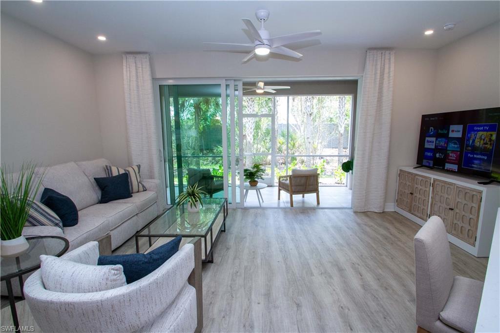 268 Indies Drive East, Unit 102 Naples, FL 34114 - Photo 11 of 48 a living room with furniture and a wooden floor