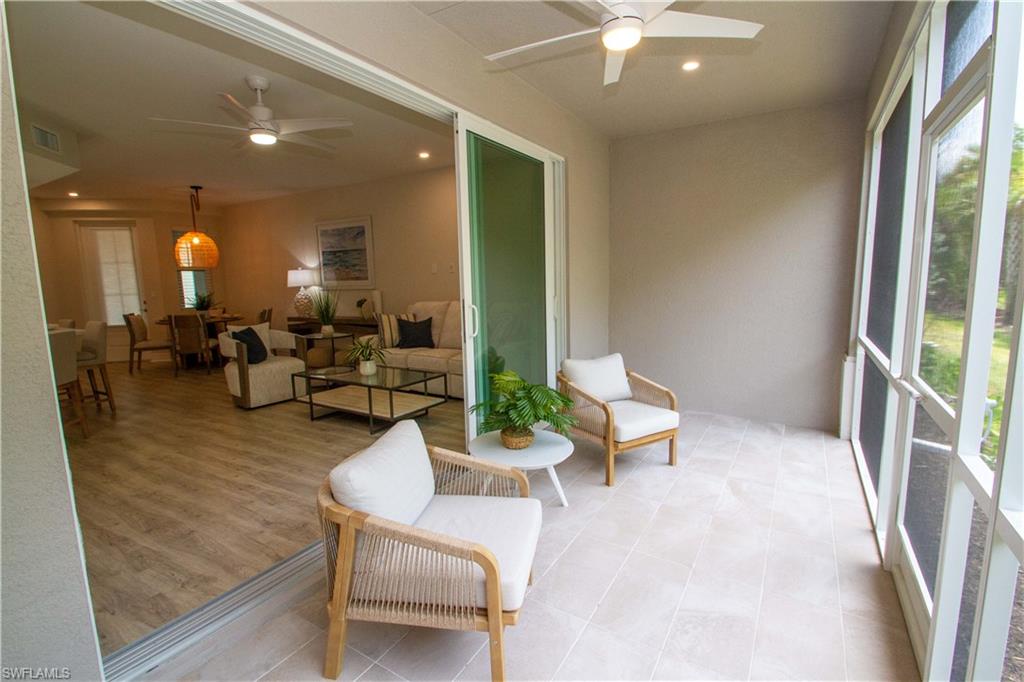 268 Indies Drive East, Unit 102 Naples, FL 34114 - Photo 13 of 48 a living room with furniture and a large window
