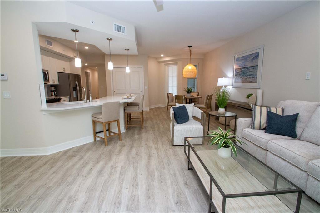268 Indies Drive East, Unit 102 Naples, FL 34114 - Photo 16 of 48 a living room with furniture and a fireplace