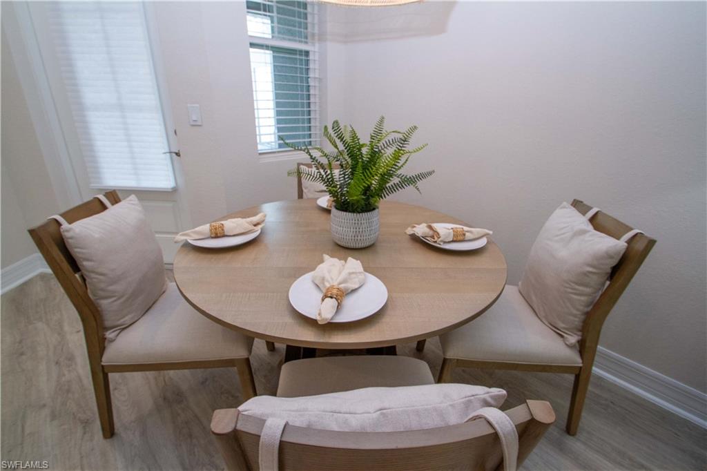 268 Indies Drive East, Unit 102 Naples, FL 34114 - Photo 17 of 48 a dining room with furniture and wooden floor