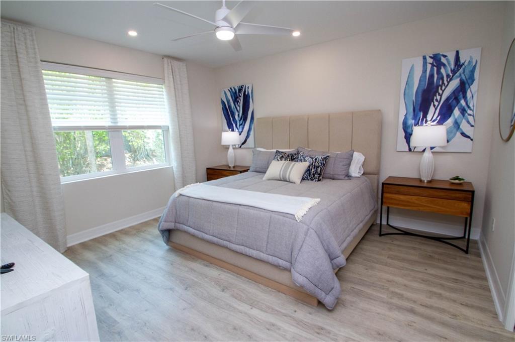 268 Indies Drive East, Unit 102 Naples, FL 34114 - Photo 19 of 48 a bedroom with a bed and a painting on the wall