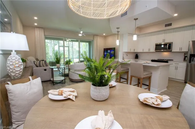 a living room with furniture kitchen view and a chandelier