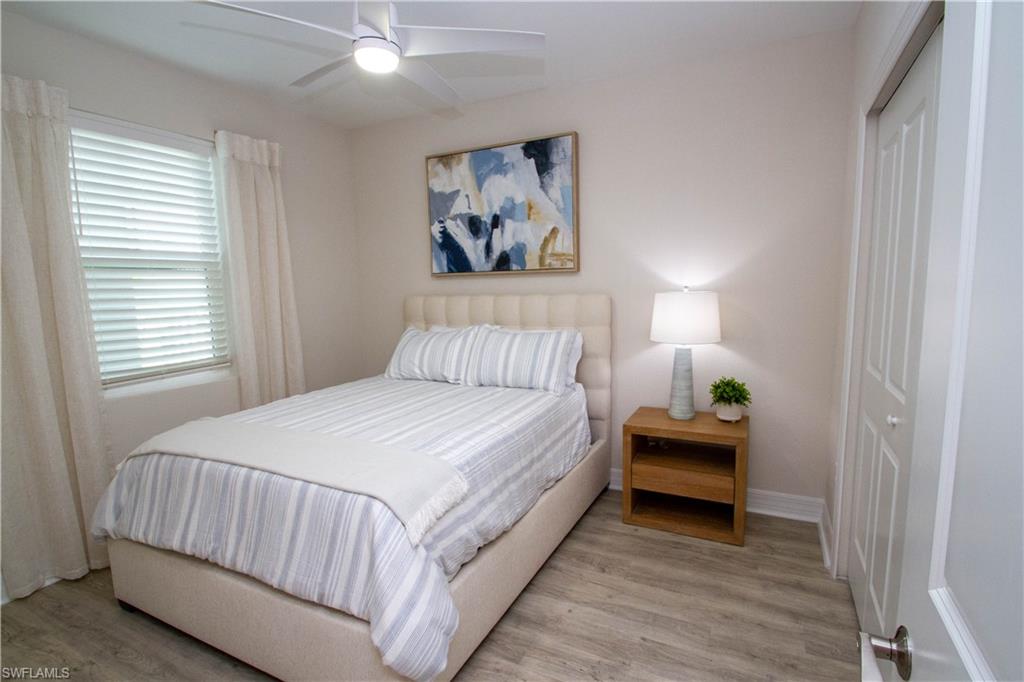 268 Indies Drive East, Unit 102 Naples, FL 34114 - Photo 27 of 48 a bedroom with a bed and a painting on the wall