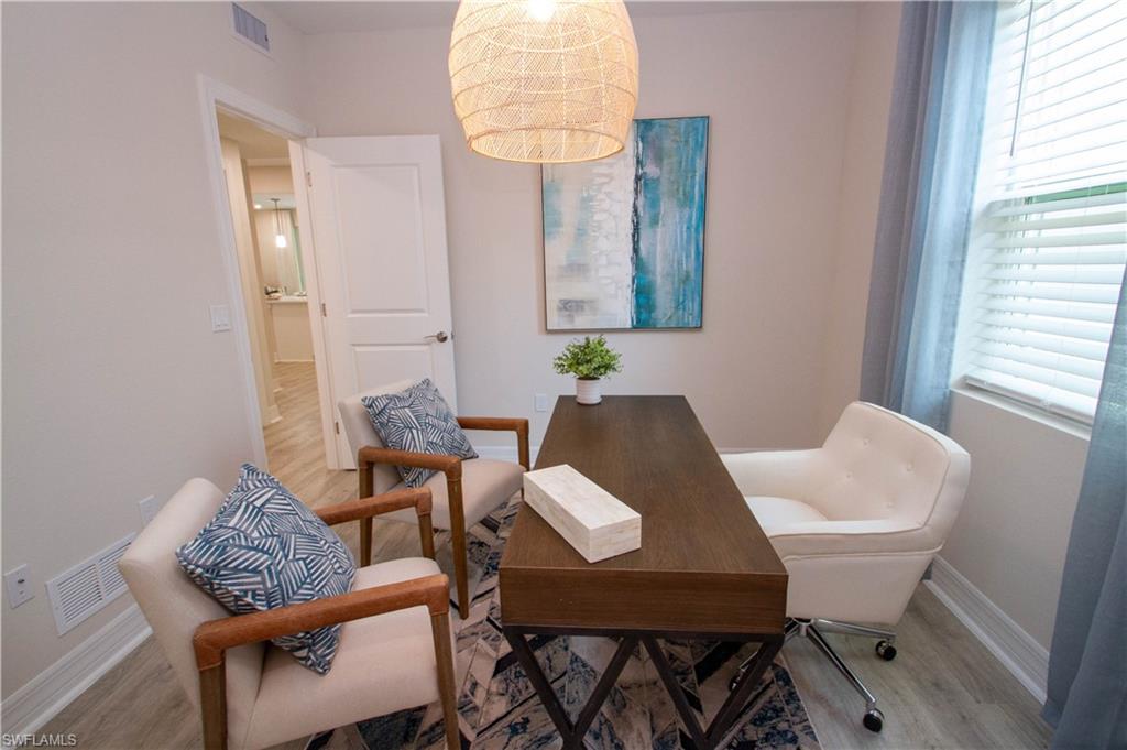 268 Indies Drive East, Unit 102 Naples, FL 34114 - Photo 34 of 48 a view of a dining room with furniture and wooden floor